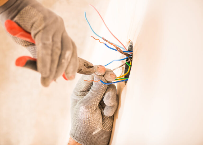 Electrician wiring a wall device