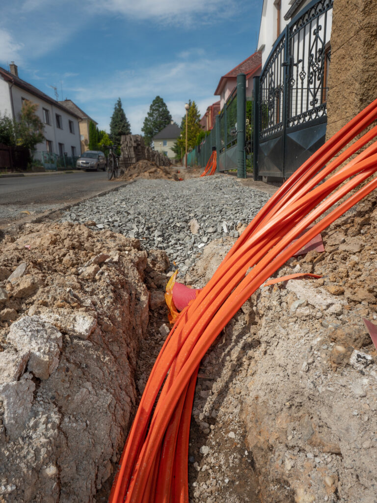 Plastic pipes containing electric cables in the ground.