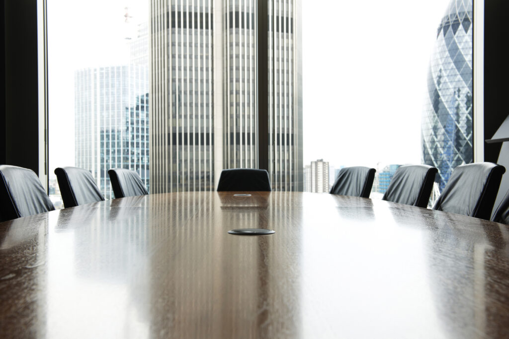 view of boardroom table with chairs and city buildings in background