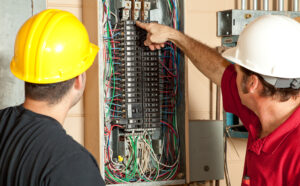 two electricians working on an electrical panel